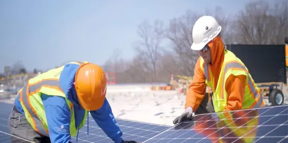 lucent-energy-workers-in-safety-gear-installing-a-solar-panel-system-on-a-snowy-day.