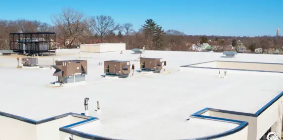 snowy-rooftop-with-HVAC-units-and-blue-trim-on-a-sunny-day