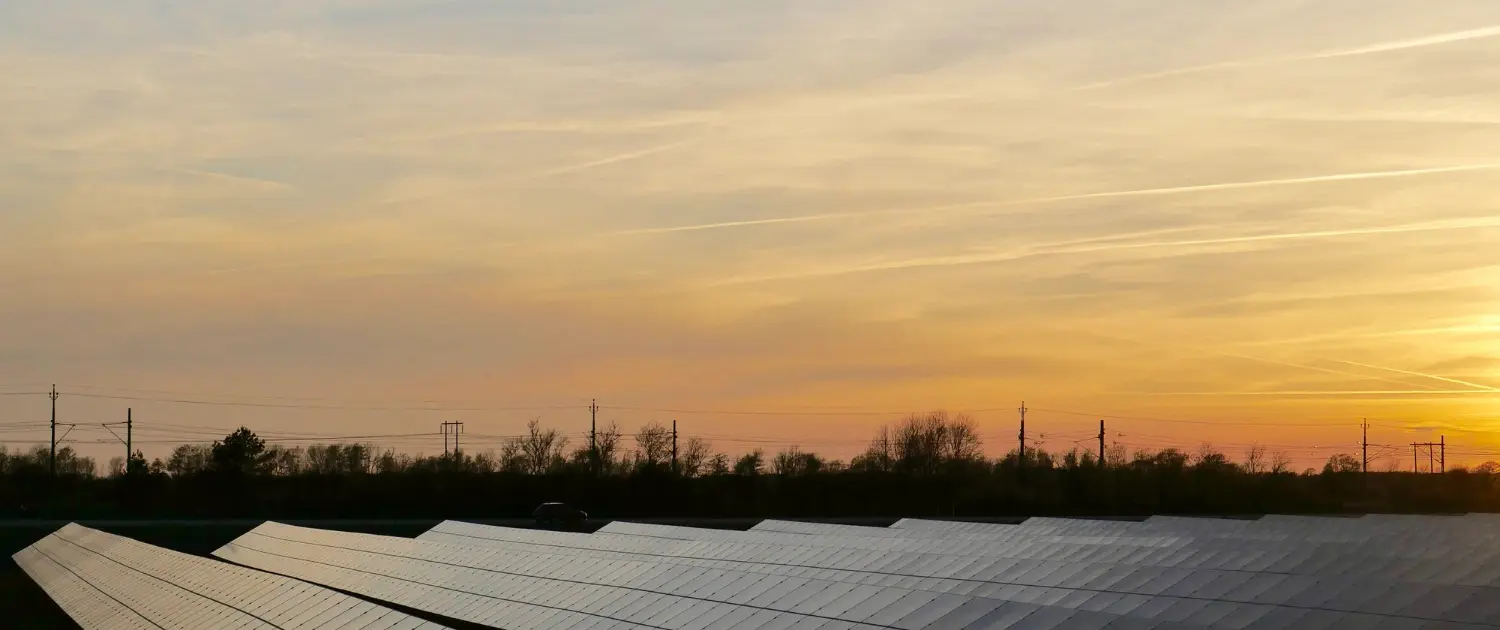 Solar-panels-at-sunset-with-a-peaceful-sky-and-tree-silhouettes-in-the-background